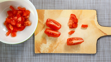 Sliced slices of ripe tomato for salad on a cutting board.