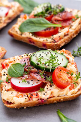 Sandwiches with cream cheese, vegetables and salami.