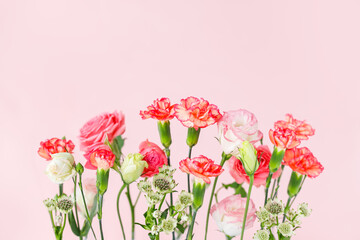 ピンクの背景にバラとカーネーションの花