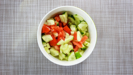 Vegetable salad in a plate of fresh tomatoes and cucumbers.