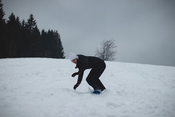 Athlete falls from a plastic snowboard and falls hard on the snow and sprawls. The boy's board got stuck and it threw him out and he did a somersault. Hard landing on the piste. Dangerous fall
