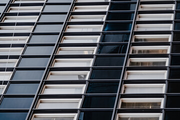 Obraz premium The facade of the building in the perspective of the modern type.Selective focus. Linney walls and windows, symmetrical photography. Finishing materials in construction. Business Centre. 