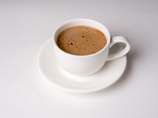 Coffee with milk in a white cup on a white background. Studio photography