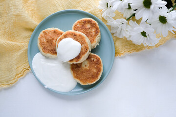 Delicious curd pancakes, Syrniki, served with sour cream. View from above. Russian, Ukrainian cuisine food. 