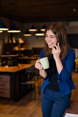 Woman using mobile phone at work in the office.
