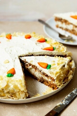 Carrot cake with walnuts an whipped cream, homemade easter cake baking, top view. Whole round cake.