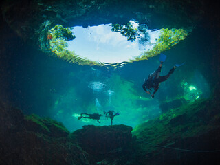 Scuba divers exiting from a cenote (Cenote Ponderosa, Playa del Carmen, Quintana Roo, Mexico) - obrazy, fototapety, plakaty