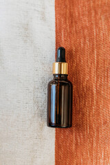 essential oil bottle on white and orang background 