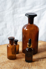 brown glass bottles of essential oil on wooden table, on white background from closep