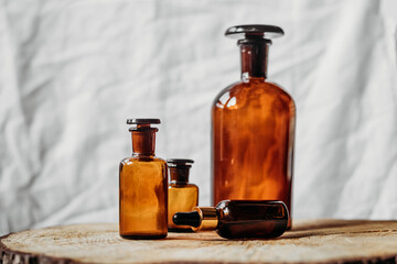 emty brown glass bottles for liquids and essential oil on wooden table, on white background 