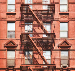 Fototapeta na wymiar Old red building with iron fire escape, New York City, USA.