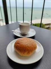 Taro filled with white sesame, White cup of coffee on the black table. 