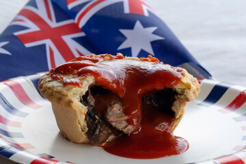 Traditional Classic Australian Meat Pie with Tomato Ketchup topping. Flag in the Background. Anzac...