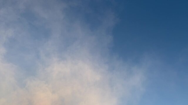 Abstract video with white smoke against the blue sky