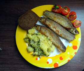 grilled river fish with bread, potatoes and tomatoes