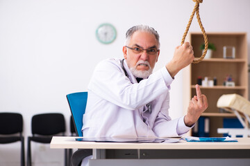 Old male doctor committing suicide at workplace