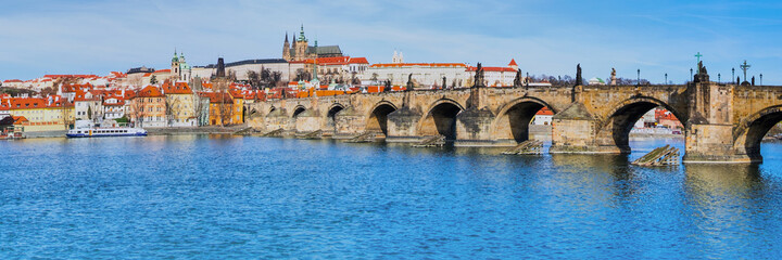 Naklejka premium Charles Bridge and historical buildings in Prague from across th