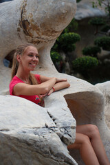 Beautiful girl in a pink t-shirt in a tropical garden