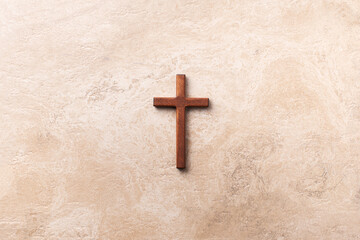 Wooden cross on marble background. Reminder of Jesus sacrifice and Christ resurrection. Easter...