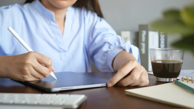 4K footage. graphic designer working with interactive stylus pen, drawing creative design on digital tablet display at workspace at home. digital device technology for creative work concept