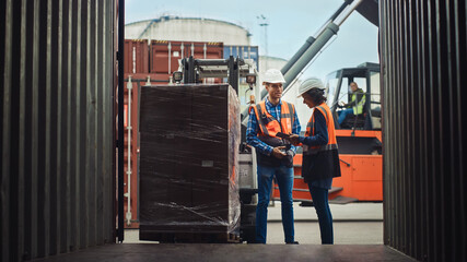 Forklift Driver Loading Shipping Cargo Container with Full Pallet with Boxes in Logistics Port Terminal. Latin Female Industrial Supervisor and Safety Inspector with Tablet Talking, Managing Process.