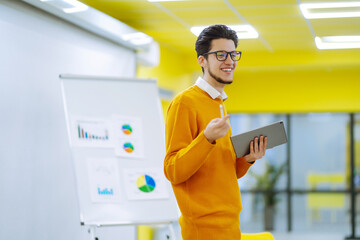 Male business coach speaker giving flipchart presentation, speaker leading consulting training...