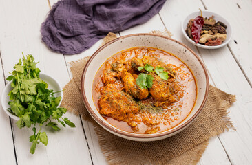 spicy gravy chicken served in a  bowl with butter naan