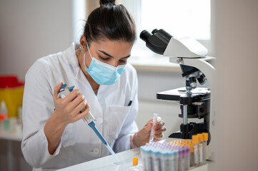 Female scientist working in a laboratory examining samples.