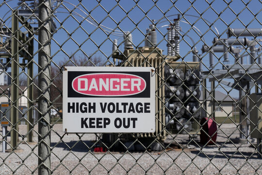 Danger - High Voltage Keep Out sign in front of an electric company substation.