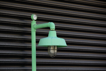 Front view, antique electric street lamp in front of black metal background