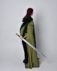 full length portrait of red haired girl wearing celtic, green medieval gown with fantasy velvet...