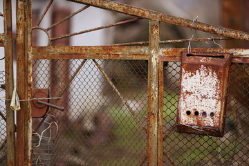 old rusty mailbox hanging on a rural fence mesh with newspaper