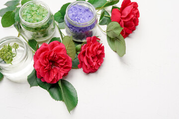 eco beauty treatment bottles with pink roses on white wooden backdround