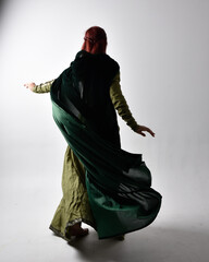 full length portrait of red haired girl wearing celtic, green medieval gown  and velvet cloak with...