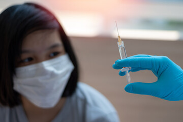 World immunization week and International HPV awareness day concept. Teenager woman having vaccination for influenza or flu shot or HPV prevention vaccine with syringe by nurse or medical officer.