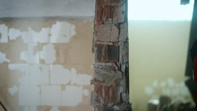 Side view. Workers break the wall with heavy hammers.