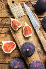 Sliced purple figs on a cutting Board. Wooden background. Top view.