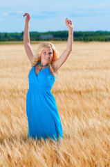 Happy womanin blue dress  in golden wheat