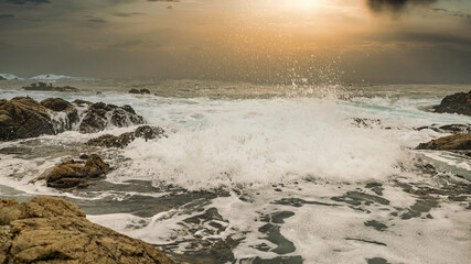 Beautiful seascape, ocean views, rocky coast, sunlight on the horizon. Composition of nature. Sunset scenery background. Cloudy sky. Water Reflection. California Seashore.