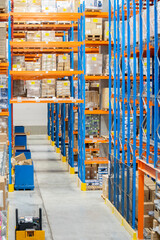 Interior view of a warehouse with racks, pallets, goods, forklifts