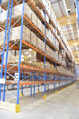 Interior view of a warehouse with racks, pallets, goods, forklifts