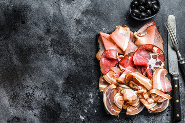 Set of cold cured italian meat Ham, prosciutto, pancetta, bacon. Black background. Top view. Copy space