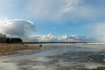 winter landscape on the lake from the shore, the surface of the lake is partially covered by ice, cold winter day
