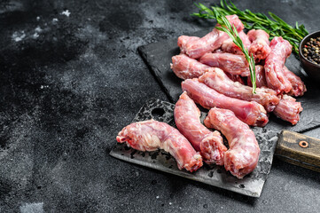 Raw Turkey neck meat on a cutting board. Black background. Top view. Copy space