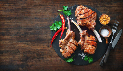 Grilled veal meat ribs cutlets with ingredients on wooden table - obrazy, fototapety, plakaty