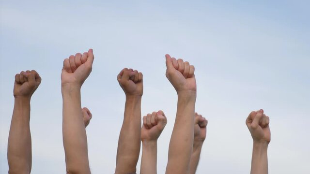 Teamwork. A group of people against the sky raises their hands up. The concept of voluntary voting, expression of consent, support for democracy.