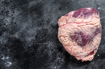 Fresh raw beef liver offal. Black background. Top view. Copy space