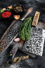 Chopping board and meat cleaver with knife. Black background. Top view
