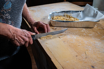 grandmother prepares homemade egg pasta