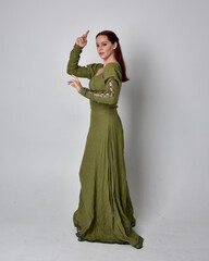 full length portrait of red haired girl wearing celtic, green medieval gown. Standing pose isolated...